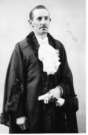 Harry Parker stands in his mayoral robes, looking past the camera with a serious expression on his face.